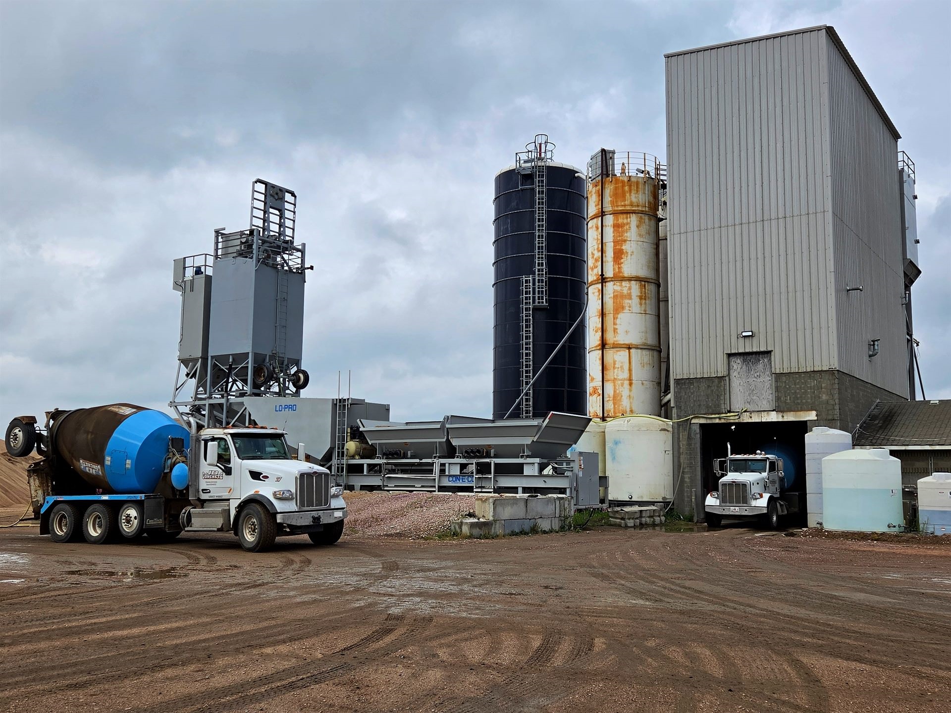 A JD Concrete portable batch plant set up on site with a mixer truck