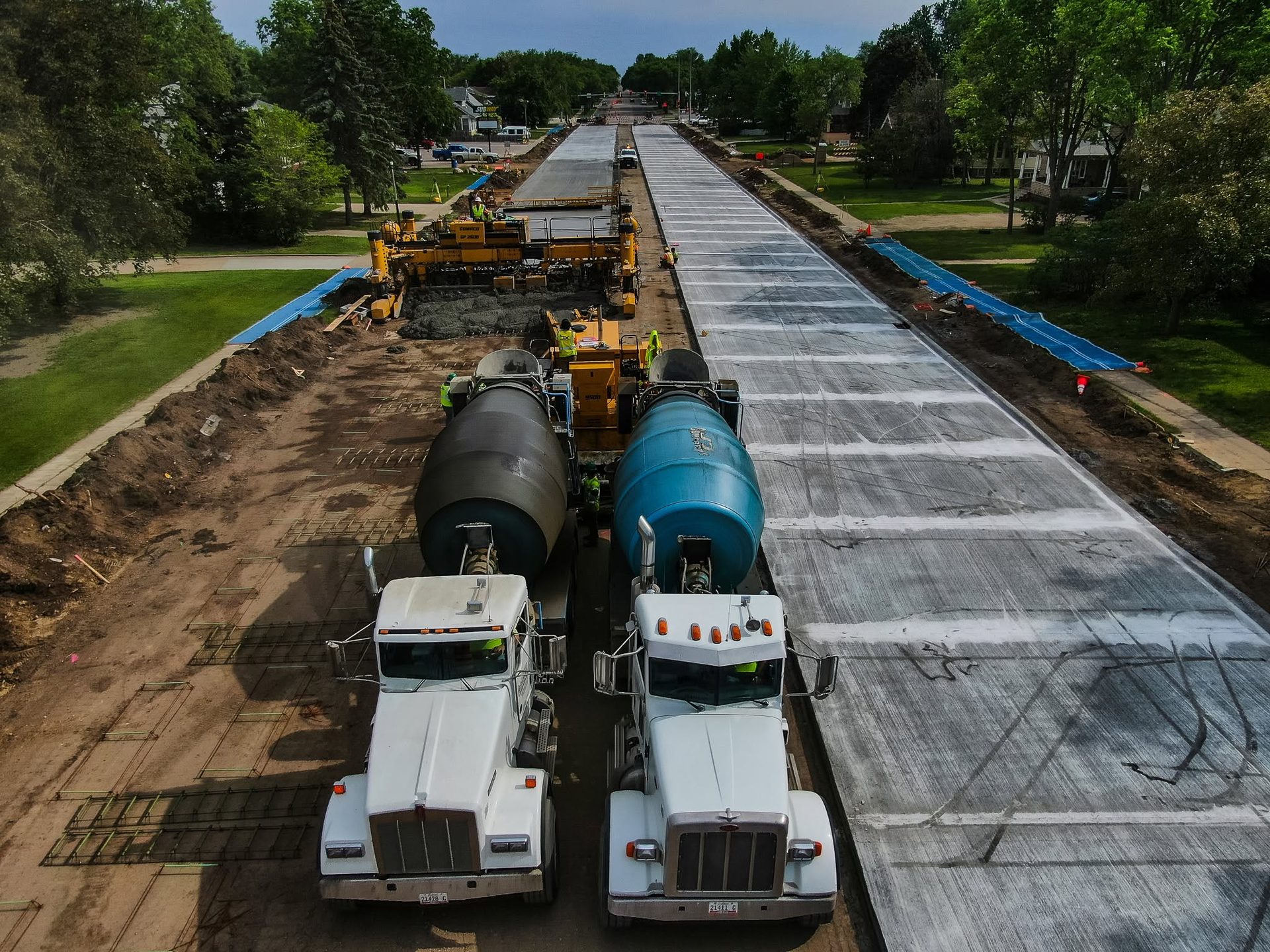 JD Concrete mixer trucks on a street paving project