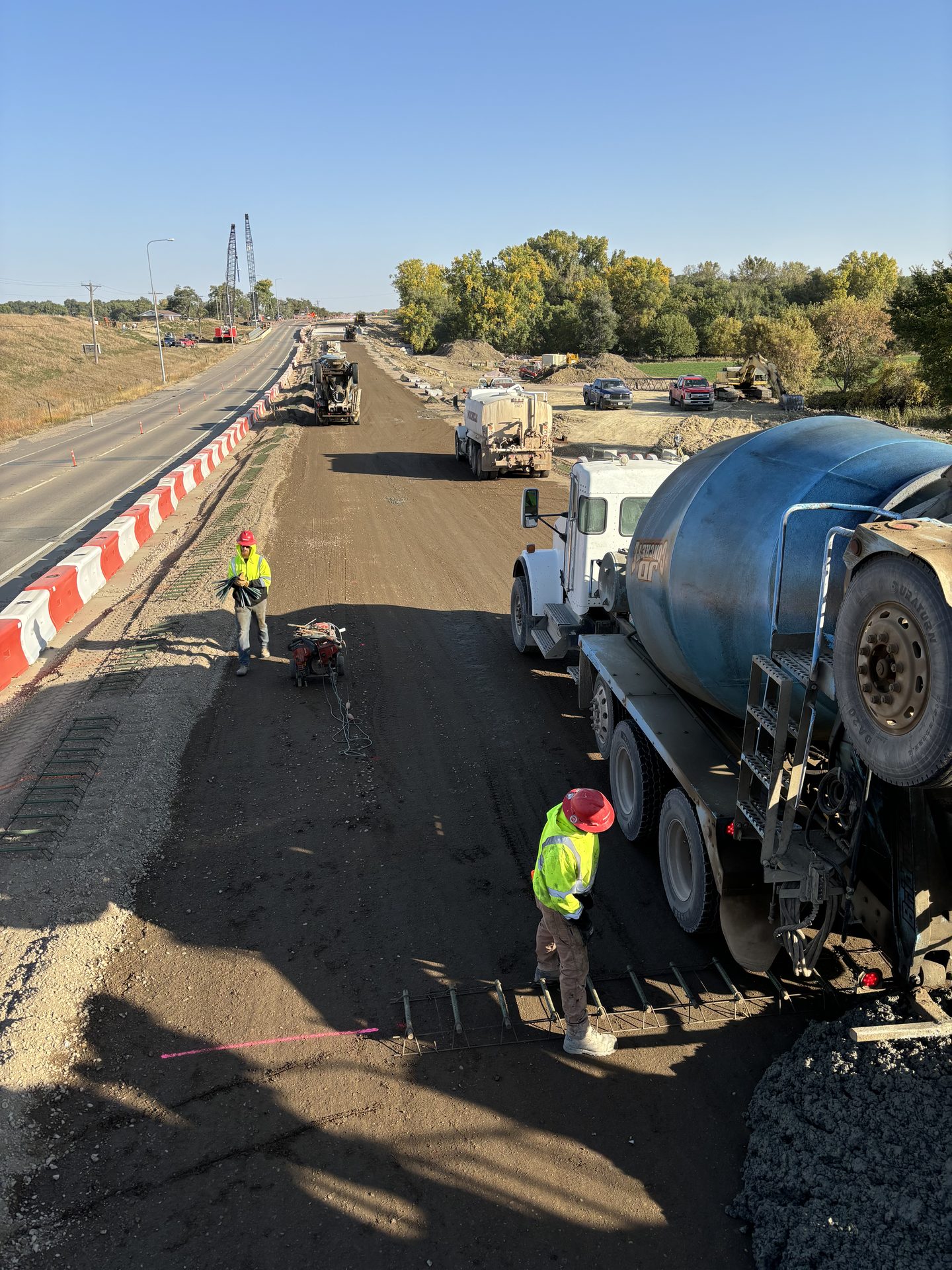 JD Concrete mixer trucks on a highway paving project