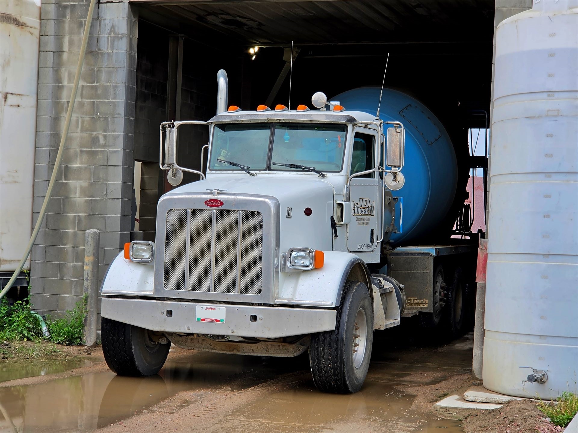 A JD Concrete Peterbilt mixer truck backed into the shop